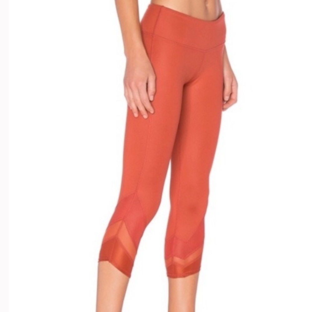 alo orange cropped leggings with mesh cutout